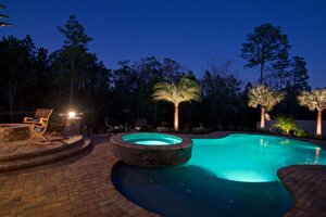 Stone patio and pool with unique outdoor lighting.